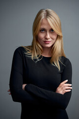 Blonde Woman Posing with Confidence in a Black Long Sleeve Dress.
