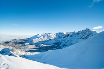 Obraz premium Tatra mountains at winter time. View of the white snow-capped peaks, frosty winter mountains. Kasprowy Wierch, High Tatra, Poland, Europe.
