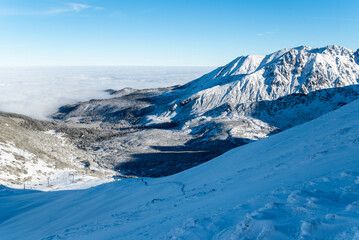 Obraz premium Tatra mountains at winter time. View of the white snow-capped peaks, frosty winter mountains. Kasprowy Wierch, High Tatra, Poland, Europe.