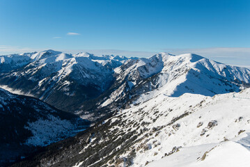 Tatra mountains at winter time. View of the white snow-capped peaks, frosty winter mountains. Kasprowy Wierch, High Tatra, Poland, Europe.