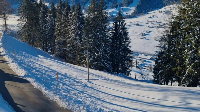 Revealing view of the alpine landscape on a crips sunny winter day under a blue sky. Filmed from Gutenberg towards Betelberg