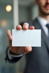 MOCKUP - blank business card held by a professional against a blurred office background