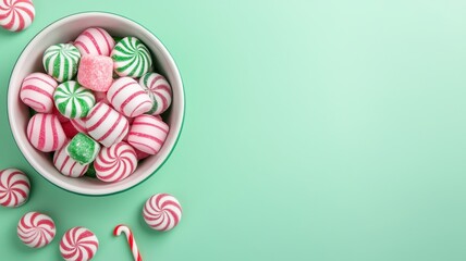 Obraz premium Festive Peppermint and Candy Canes on Mint Green Background Christmas Sweets Holiday Treats