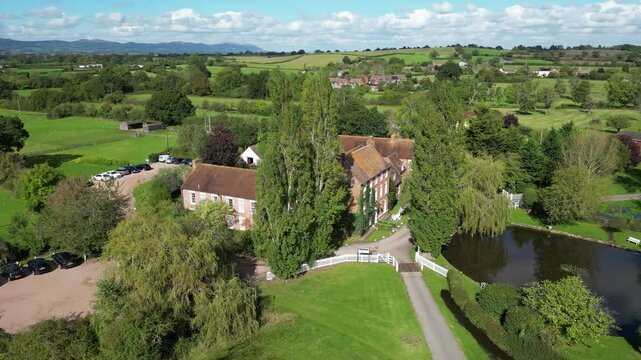 luxurious castle hotel property england illuminated by bright sunshine clear day architecture surrounding backward aerial drone shot real estate luxury uk sunny scenic view 