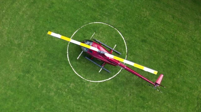 helicopter parked green grass field heliport vibrant colors perspective highlight aviation london dynamic rotating aerial drone shot helipad scenic view travel air 