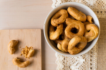 Artisanal homemade typical apulian taralli bowl wooden cutting board, crumbles, baked snack aperitif south italian culture. Flat lay 