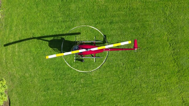 helicopter parked green grass field helipad shadow against vibrant landscape aviation top down birdseye aerial shot view upwards heliport london scenic travel 