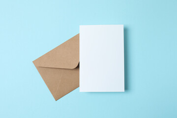 White paper card with craft envelope on blue background