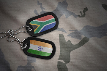 vintage army blank, dog tag with flag of south africa and india on the khaki texture background....