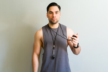 Personal trainer holding stopwatch and whistle ready for workout