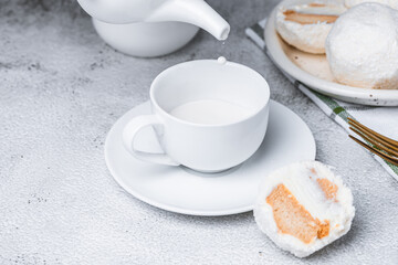 Milk in a white cup and cookies on a gray background.