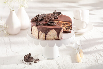 Homemade and sweet cheesecake with cookie served on white table.