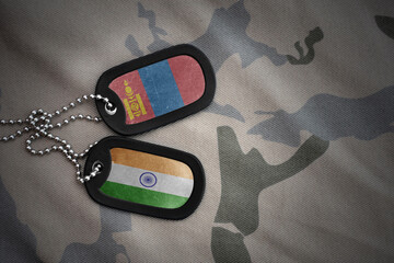 vintage army blank, dog tag with flag of mongolia and india on the khaki texture background. military concept.