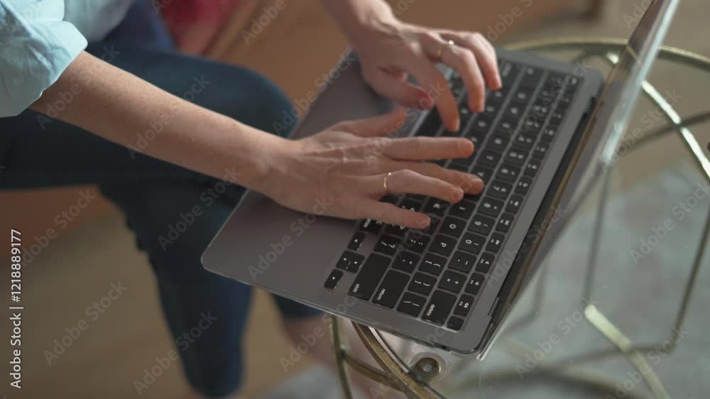 Poster a closeup view of hands typing intently on a laptop keyboard while sitting in a cozy and comfortable