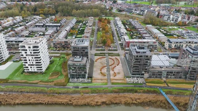 new development area de zaat temse belgium scene includes riverside apartments historic boelwerf crane scheldt river backward aerial drone shot view urban landscape waterfront 
