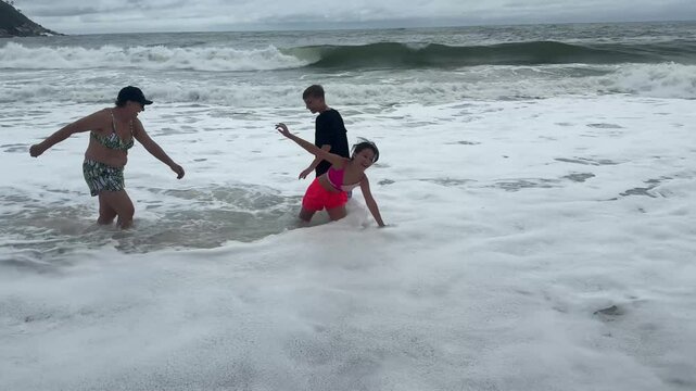 av&oacute; com netos nas ondas do mar 