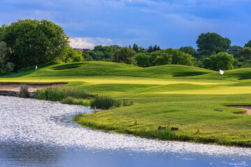 Obraz premium A golf course with a lake in the background