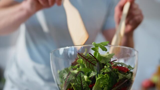 Chief hands mixing salad preparing food at cozy kitchen closeup. Guy cooking