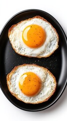 Crispy fried eggs served on a black plate with pepper seasoning in a bright kitchen setting