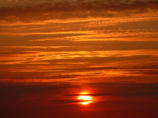 il sole al tramonto in un cielo rosso e arancione