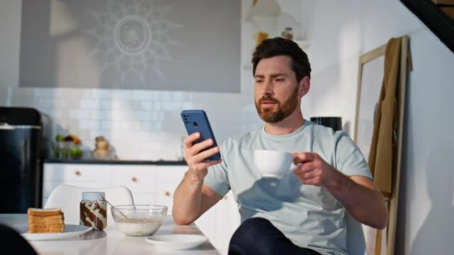 Morning man texting mobile phone sitting with coffee cup closeup. Relaxed guy