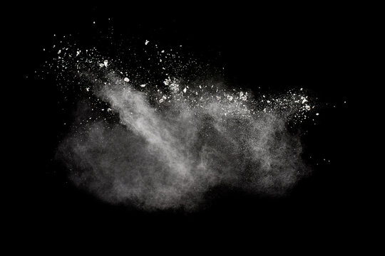 White powder explosion isolated on black background.White dust particles splash.