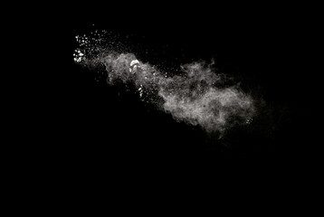 White powder explosion isolated on black background.White dust particles splash.