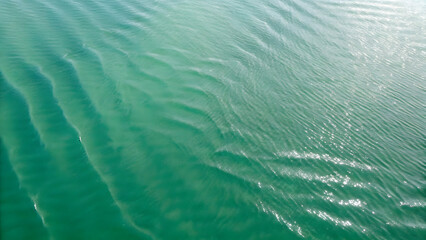 Top view of mint green water. The waves and ripples create an abstract pattern