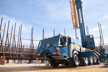 Heavy all-terrain mobile crane at construction site. Heavy lifting machinery. Car mounted crane low angle view