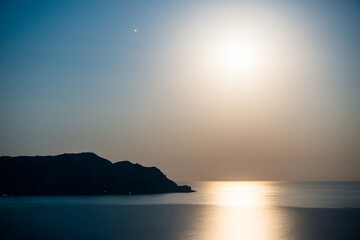 Night picturesque seascape with rising moon and moon path. South coast of Crimea peninsula. Russia