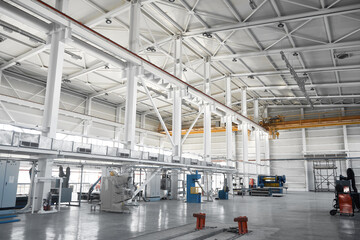Yellow overhead traveling gantry crane beam on the pillars and truss ceilings of industrial building. Crane runway girder and metal structures. Interior of industrial storehouse or hangar