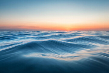 Obraz premium Sunset over calm ocean waters creates a serene atmosphere with vibrant colors on the horizon