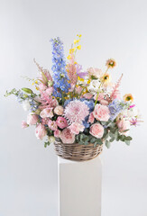 Festive floral arrangement for Valentine's Day and International Women's Day with pink roses, blue hydrangeas, and colorful seasonal flowers in a woven basket