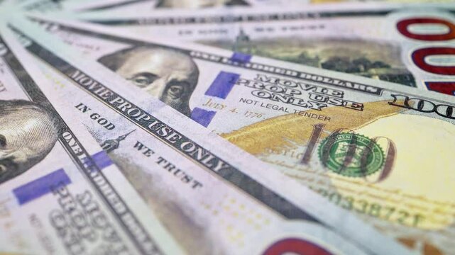 A large number of 100-dollar bills, the national currency of the United States, a close-up view from above, rotating clockwise.