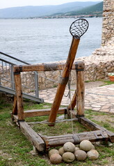 Ancient catapult with stone balls by the river. Ancient military technology
