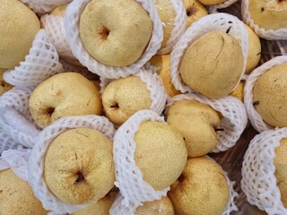 Sweet pears wrapped in foam nets, displayed for sale