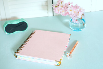 An elegant piece of jewelry in a soft horn-colored frame on a spiral, placed on a pastel blanc table. Handle - a forged handle with crystal. ideal for work or creative space.