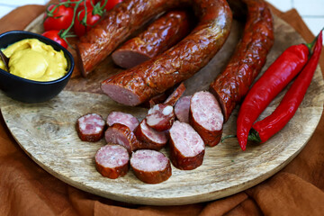 Homemade sausages with mustard on a wooden board.