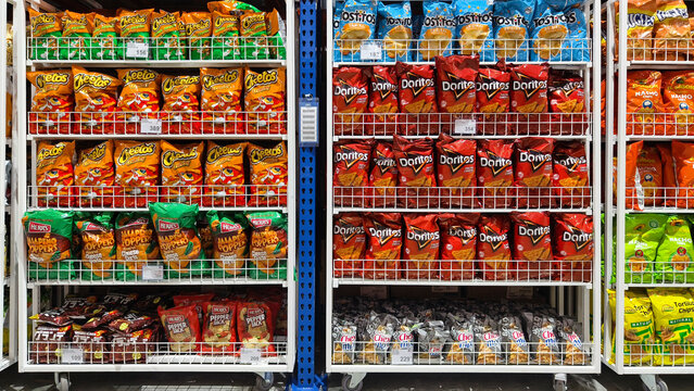 Organized shelves stocked with chips and snacks in a supermarket aisle