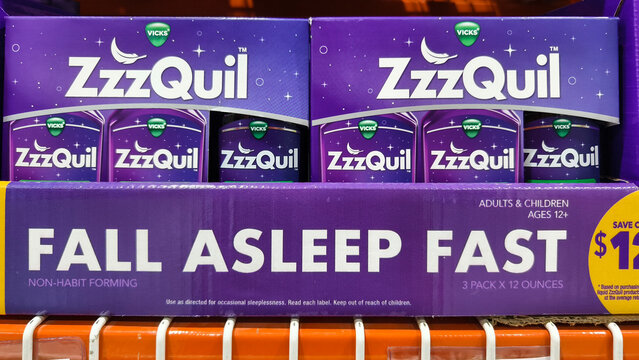 Display of ZzzQuil sleep aid boxes on shelves with promotional text