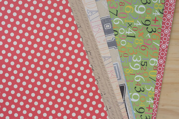 set of decorative scrapbooking sheets arranged in staggered form on wood