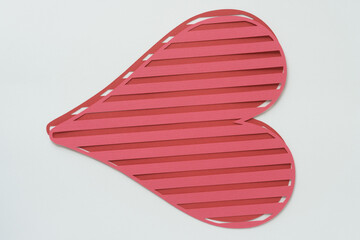 layered striped heart shapes machine-cut from pink and red crafting paper and arranged on blank paper