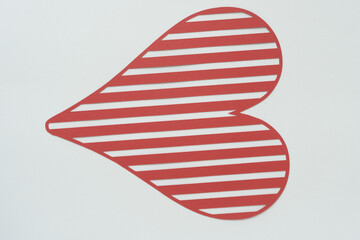 Obraz premium isolated striped heart shape machine-cut from red crafting paper and arranged on blank paper