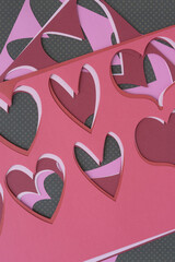 stencil with heart pattern machine-cut from a variety of pink and red crafting papers and arranged...