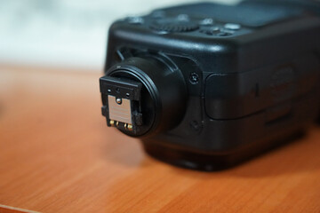 Close-up view of a camera flash attachment on a wooden table