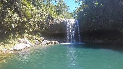Naklejka premium Serene Waterfall in Lush Tropical Paradise