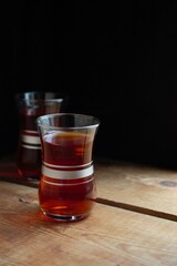 Black tea in Turkish cups, on a wooden table, low key, light from the window.