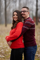 Fototapeta premium Expecting couple in nature with blurred background