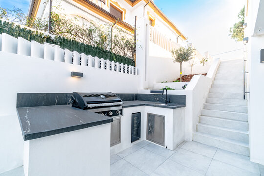 a private outdoor kitchen barbecue area in the garden of luxury mediterranean real estate 