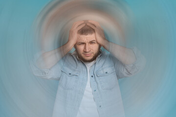 Man suffering from headache and dizziness on light blue background